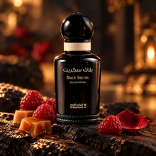 Black Secret EDP bottle in warm cinematic light with raspberries, caramel and a rose petal