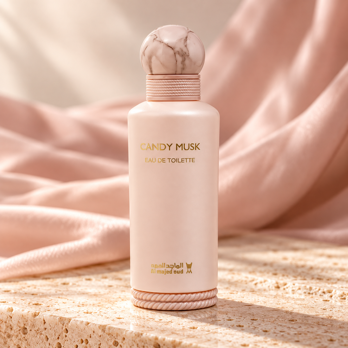 Al Majed Oud Candy Musk bottle with marbled cap on ivory stone and blush silk