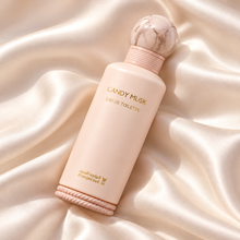 Overhead diagonal view of Al Majed Oud Candy Musk EDT bottle on ivory silk