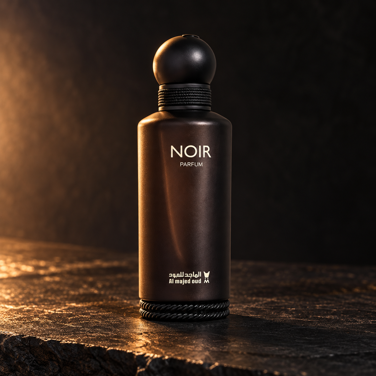 Al Majed Oud Noir Parfum bottle photographed on dark stone with warm side lighting