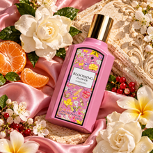 Overhead Blooming Flower Gardenia pink bottle on silk and ivory stone with flowers and berries