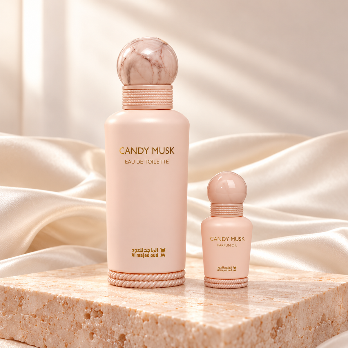 Candy Musk 150ml Eau de Toilette and 15ml perfume oil bottles on peach stone with ivory silk
