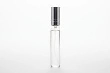 Clear glass perfume sample bottle with silver spray cap on white background
