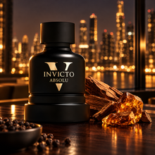 Invicto Absolu perfume with sandalwood amber and black pepper in a nighttime editorial scene
