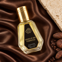 Overhead view of Vanille En Tobacco 50ml bottle on brown satin beside cacao