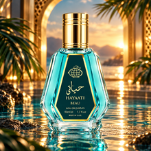 Hayaati Beau 50ml perfume bottle in a golden archway with turquoise water and tropical leaves