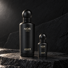 Al Majed Oud Noir 150ml Parfum and 15ml perfume oil bottles on dark charcoal stone