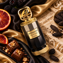 Overhead Momento Liquid Gold bottle on black and gold silk with fruit praline and tonka